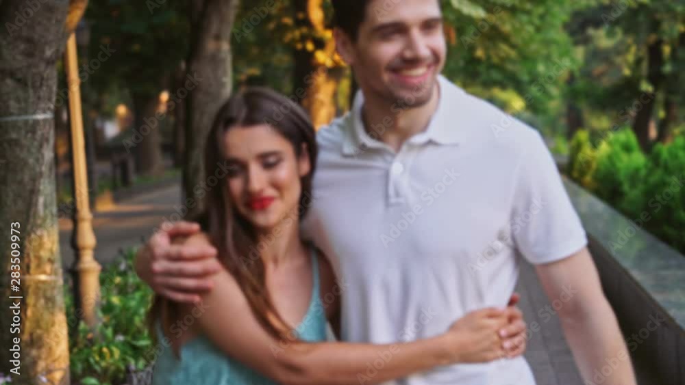 Young happy loving couple walking outdoors at the street talking with each other Young happy loving couple walking outdoors at the street talking with each other