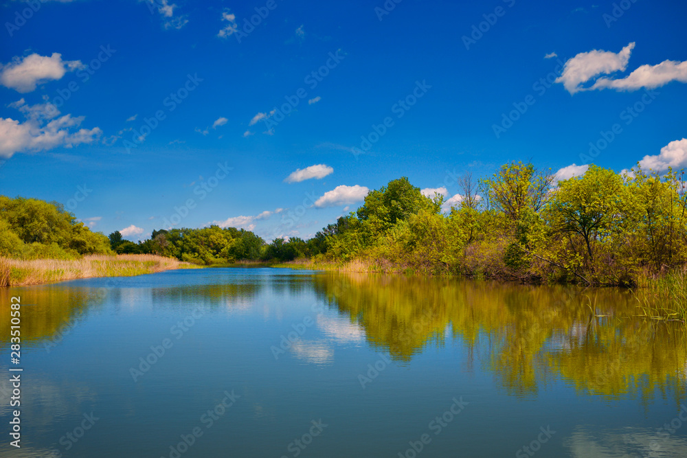 Obraz premium The beautiful Tisza lake with a nice cloudscape and a nice reflection on the water