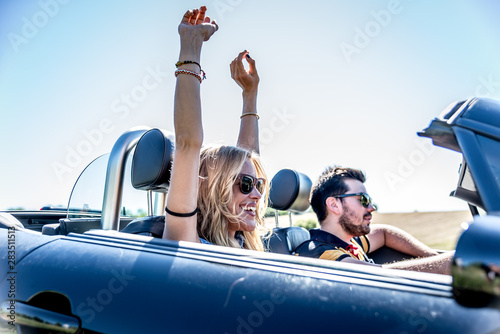 Couple driving on a convertible car and having fun