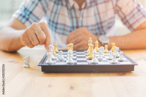 Closeup image of a leader moving and playing chessboard game.