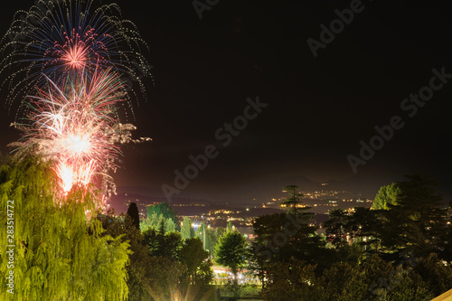 Firework show on Lake Garda, celebration (Sant Ercolano). In the city of Toscolano Maderno Italy. Aerial view.