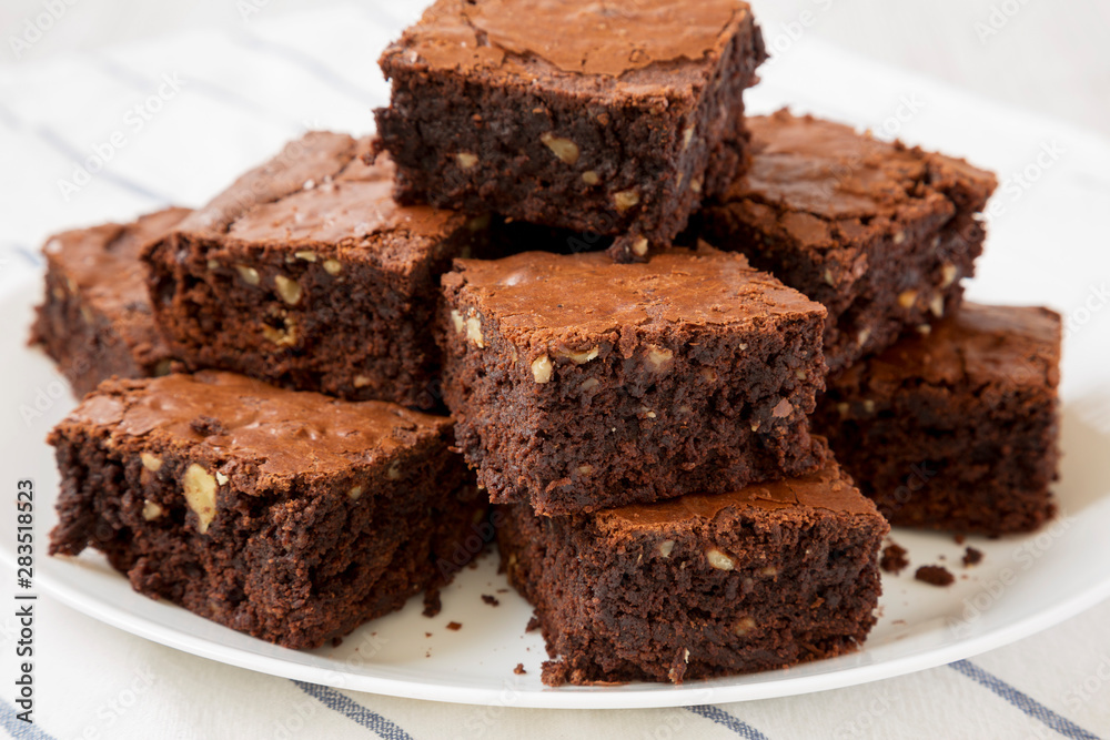 Homemade chocolate brownies on a white plate, side view. Close-up.