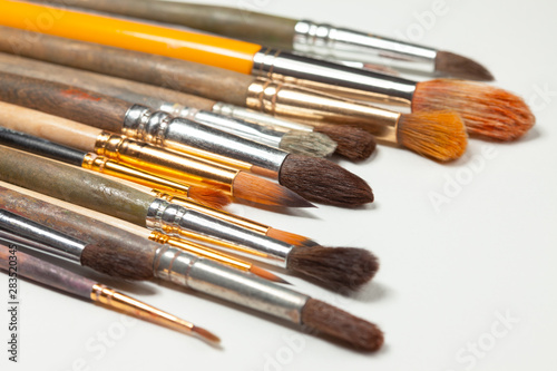 Set of real paintbrushes on white canvas