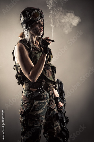 woman in uniform with guns rests smoking cigar