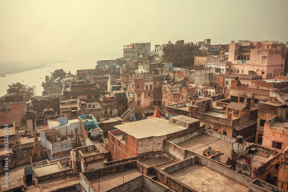 Buildings near Ganges river, historical cityscape of Varanasi, view over roofs of the poor brick houses, India