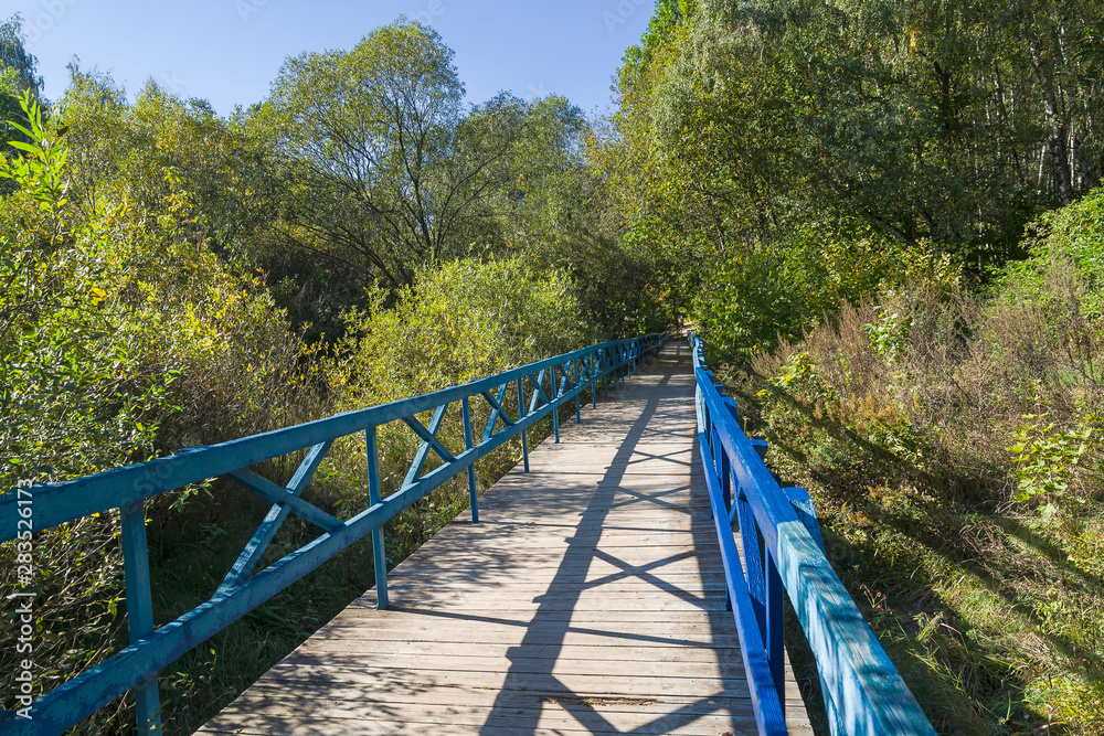 A wooden pedestrian bridge in a small ravine. A wooden pedestrian bridge in a small ravine.