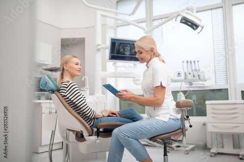 Dentist talking to her client before the procedure.
