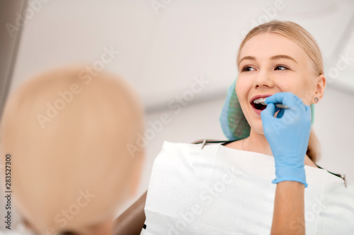 Smiling young woman having her braces examination.
