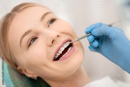 Patient fixing her orthodontic braces in dental clinic.