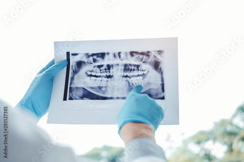 Dentist consulting with patient presenting results on Dental x-ray film About the problem of the patient photo