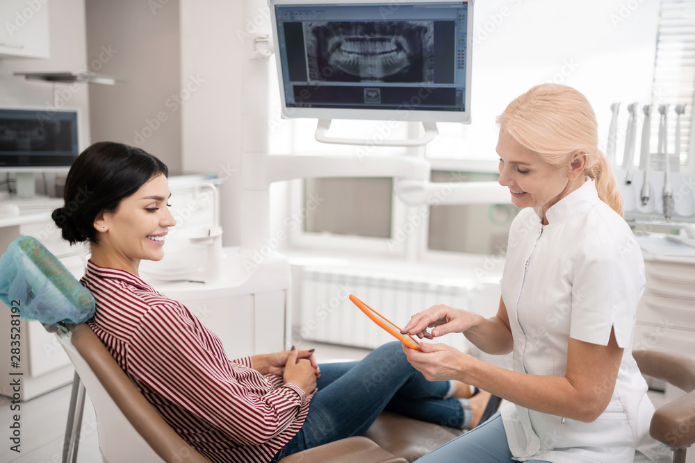 Dentist looking for date of new appointment with her patient. Dentist looking for date of new appointment with her patient.