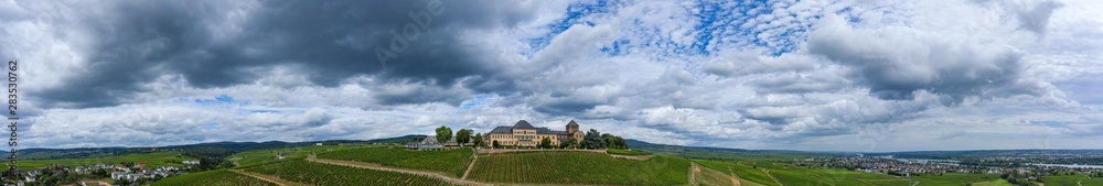 Panoramaaufnahme der Weinberge und Schloss Johannisberg/Deutschland bei Gewitterstimmung