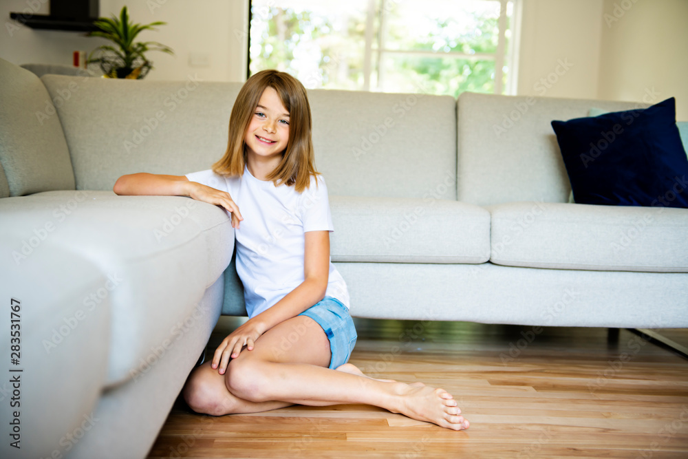 A Cute girl sitting on the sofa and watching TV. The child is resting at home. A Cute girl sitting on the sofa and watching TV. The child is resting at home.