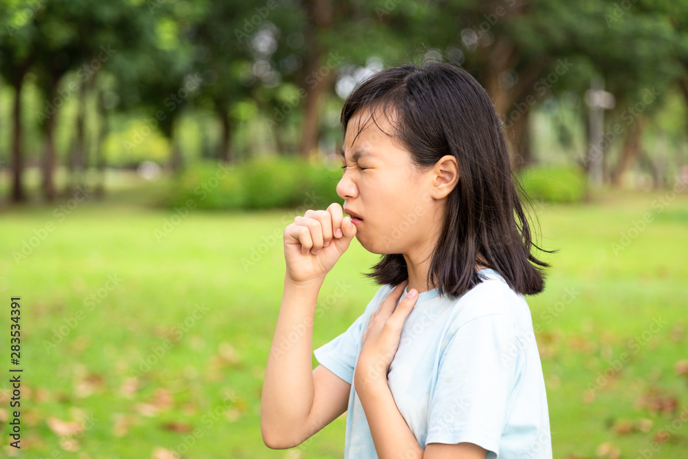 Sick child girl suffering from sore throat,painful swallowing,asian female patient have coughing,irritation sore throat,holding hand on her neck ,inflammation,bacterial infections diseases,allergies Sick child girl suffering from sore throat,painful swallowing,asian female patient have coughing,irritation sore throat,holding hand on her neck ,inflammation,bacterial infections diseases,allergies