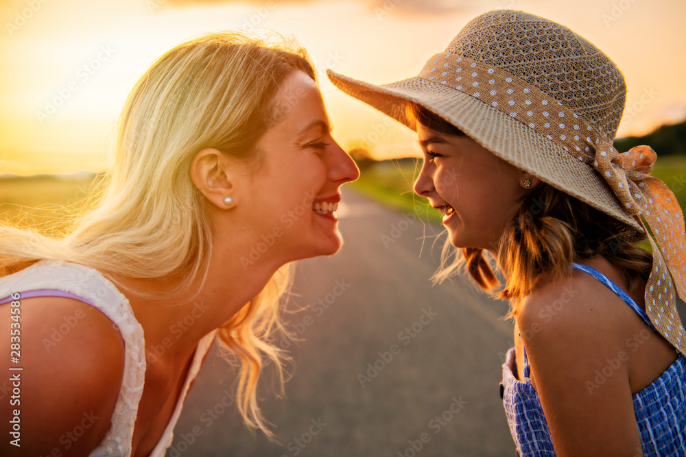 happy family at sunset. Mother and daughter having fun and playing in nature happy family at sunset. Mother and daughter having fun and playing in nature