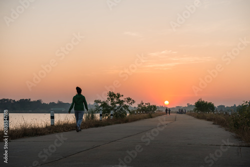 woman walking on sunset background