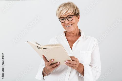 Portrait of smiling adult woman wearing eyeglasses reading book