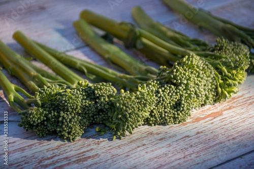 Bunch of fresh broccolini on a wooden table background. Healthy eating. Cooking ingredient. Hybrid of broccoli and chinese broccoli photo