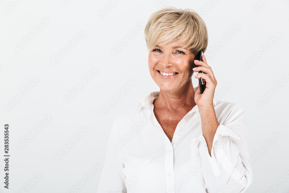 Portrait closeup of positive adult woman with short blond hair smiling and talking on cellphone Portrait closeup of positive adult woman with short blond hair smiling and talking on cellphone