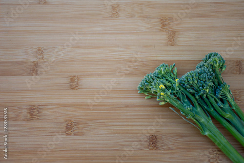 Bunch of fresh broccolini on a wooden board background. Healthy eating. Cooking ingredient photo