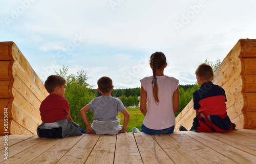 Children on high wooden slide. Happy cheerful summer vacation on fresh air. © Victoria