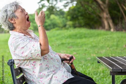 Obraz na plátně Asian senior woman has sleepy expression,elderly woman yawning covering open mou
