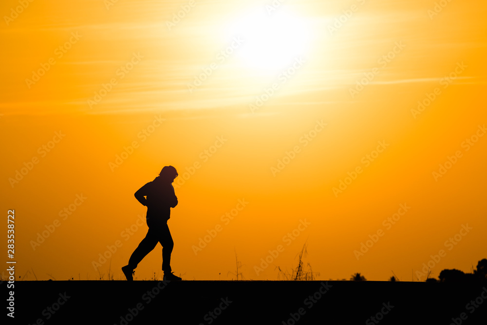 Silhouette man running on sunset background