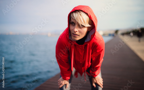 Картината върху платно Front view portrait of young sportswoman standing outdoors on beach