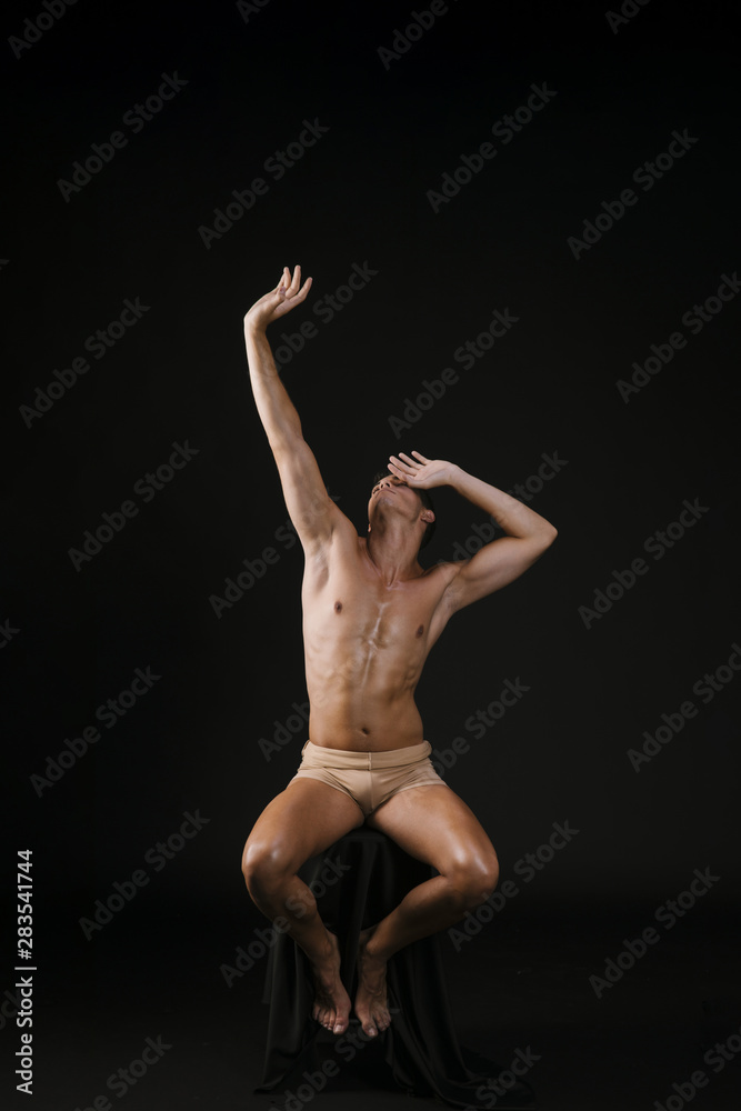 Obraz premium Nude man on chair holding head at forehead