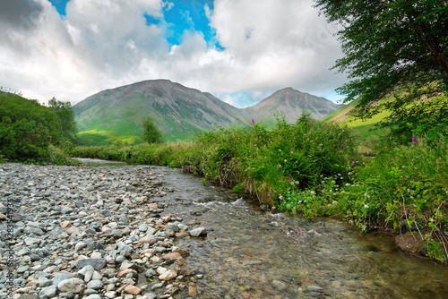 Kirk Fell and Great Gable mountains viewed on a summers evening from Mosedale Beck as it passes though Down in the Dale, Wasdale Head, Lake District photo