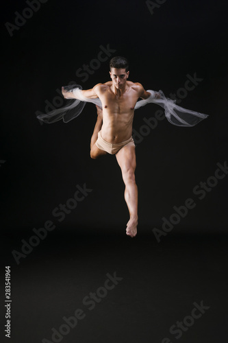 Male acrobat running on black background