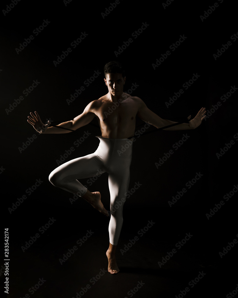 Obraz premium Male dancer standing against black background with extended hands