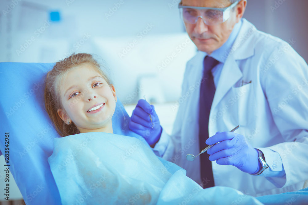 Fototapeta premium Little girl sitting in the dentists office