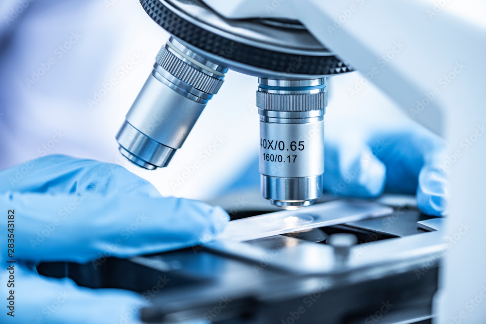 Researchers working with microscopes Wearing blue gloves Researchers working with microscopes Wearing blue gloves