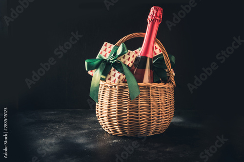 Christmas gift hamper with champagne and gift on black. Space for your greetings. greeting card
