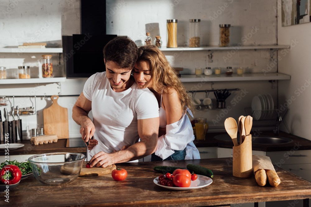sexy couple smiling while cooking together in kitchen Stock Photo ...