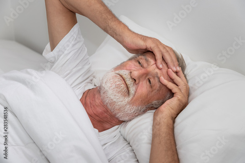 Canvas Print Senior elderly man on bed eye open sleeplessness and worry, with white blanket i