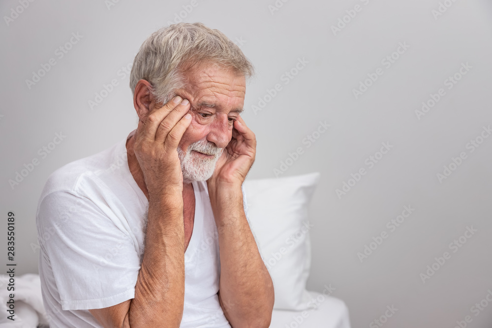 Senior elderly man sitting on bed with depressed after waking up in morning