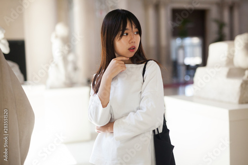 Free Download Young chinese woman standing in museum of ancient sculpture - GFXLoad