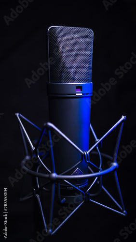 studio condenser microphone, isolated on black. with blue light photo