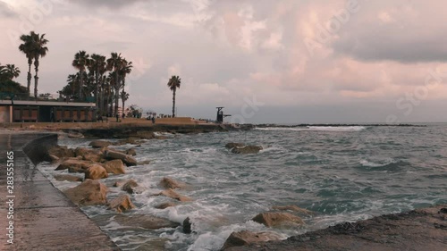 Close up view of city beach. City beach at stormy weather. Tourist area with promenade at storm. Big sea waves crashing on stones. Tourist zone at rainy weather. Promenade at windy stormy weather photo