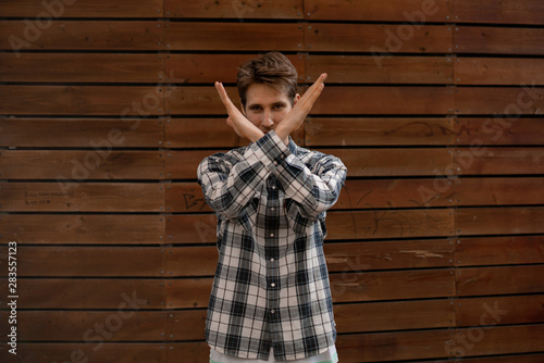 young man with crossed hands in front of face, stop gesture sign