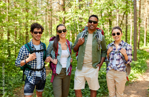 travel, tourism, hike and people concept - group of friends with backpacks in forest © Syda Productions