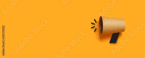 Refer a Friend. Business concept image with paper cup megaphone on orange background with copy space. Attention concept announcement. Minimal flat lay