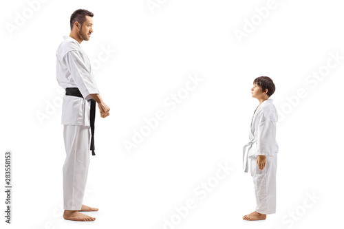 Karate kid standing and looking at his karate instructor