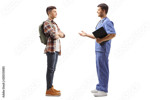 Male doctor in a blue uniform talking to a male student