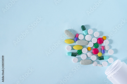Flat Lay, Top View of Colorful, Assorted pharmaceutical medicine pills. Many pills and tablets isolated on blue background with copy space. medicine concept.