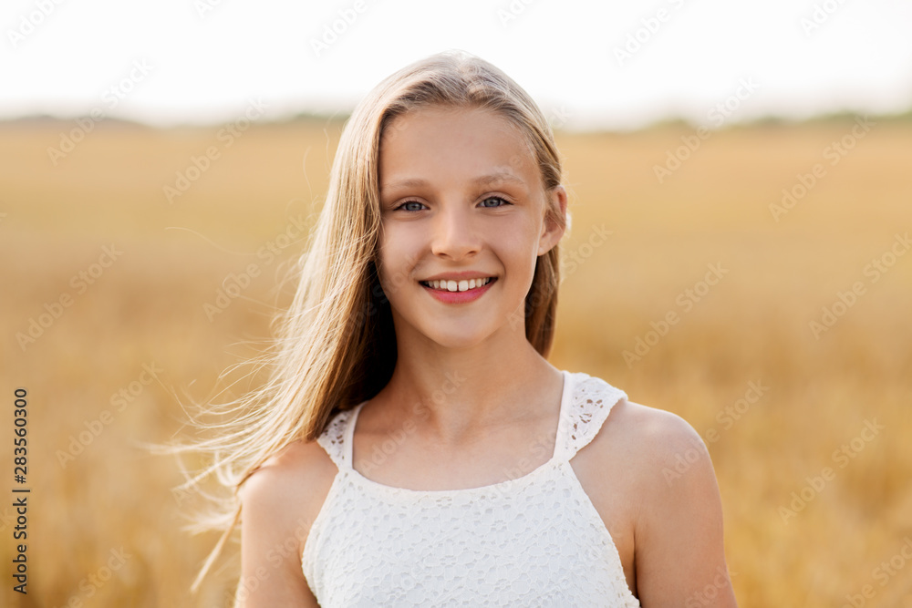 nature and people concept - smiling young girl on cereal field in summer nature and people concept - smiling young girl on cereal field in summer