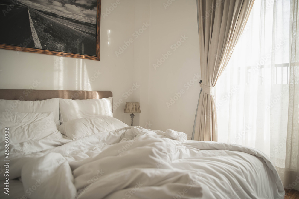 White interior of cozy bedroom with morning light. Cozy bedroom beside window and sunlight in the morning horizontal background. Stock Photo Adobe Stock
