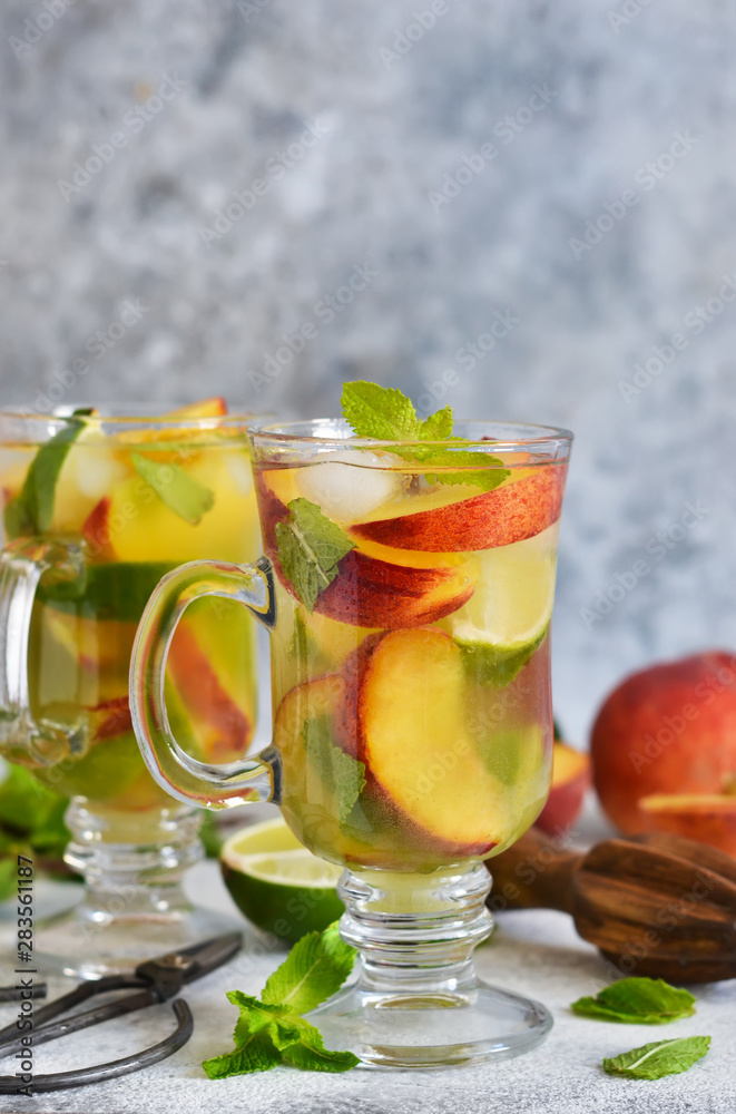 Cold summer drink with peach, lime and mint on a concrete background. Cold summer drink with peach, lime and mint on a concrete background.